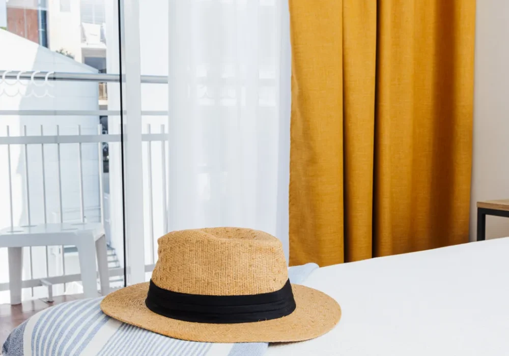 Imagen bonita montada de toalla sombrero en el pie de la cama de fondo las vistas de la calle